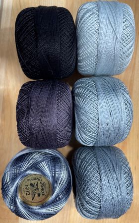Finca #12 Pearl Cotton in three shades of solid grays and two blacks, one is variegated.