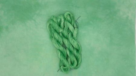 Hand dyed threads, 6 strand cotton floss, #12 & #8 pearl cottons and cotton fabric in a soft green with a hint of yellow.