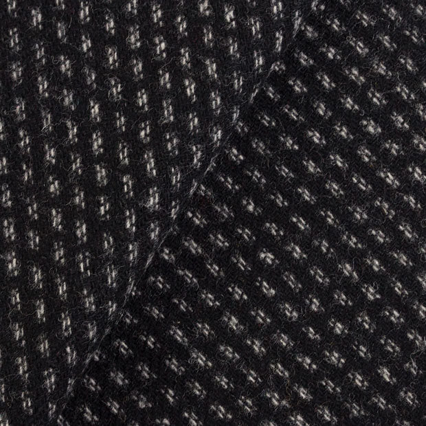 Wool fabric with black background and a white double running stitch woven into in in stripes