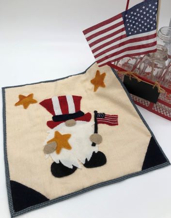 Wool applique gnome dressed as Uncle Sam holding a flag and a star in a 12