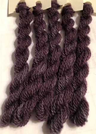 This hand dyed wool thread is a medium dark, variegated purple that looks purple or gray depending on the light! 