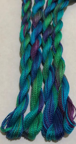 Hand dyed #8 pearl cotton thread in green, turquoise and purple - the colors of a mermaids tail.