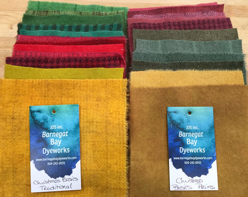 Two packs of  reds, greens and golds five inch, hand dyed wool  squares one in traditional brighter colorway and one in primitive colorway .