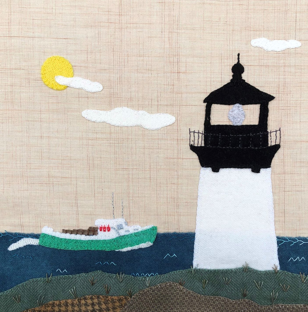 Wool applique nautical scene of a lobster boat passing a lighthouse.