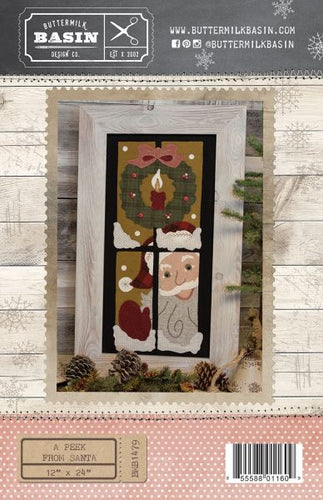 A Peek From Santa Pattern by Buttermilk Basin features Santa peeking out a window with a wreath and snow in wool applique