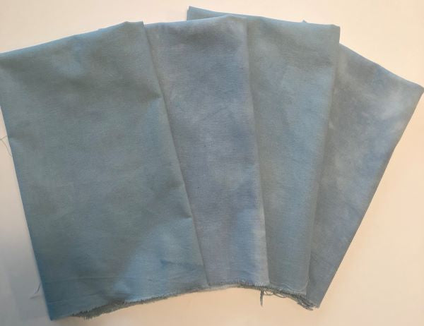 Four pieces of hand dyed cotton in a soft dusky blue.