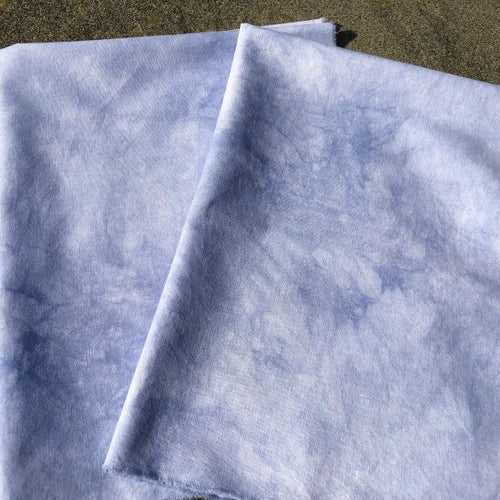 Hand dyed cotton fat quarter pieces of a slightly mottled, medium light blue.