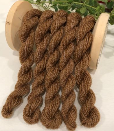 Skeins of hand dyed wool threads variegated brown wool thread in a  dark medium brown. 