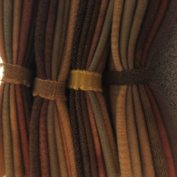A stack of bundles in browns and tans hand dyed wool for endless possibilities!