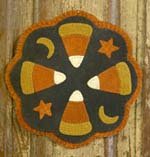 Wool applique mat with four large candy corns separated by quarter moons and stars.
