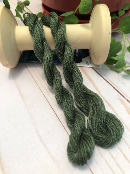 Skeins of a dark medium green, hand dyed wool thread for wool applique.