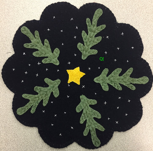 Navy scalloped mat with four primitive evergreen trees, a yellow star in the center and embroidered x snowflakes.