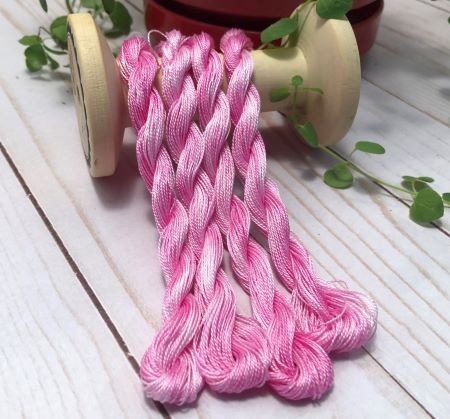 Hand dyed skeins of a variegated #8 pearl cotton in light to dark pink/fuchsia.
