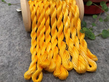 Load image into Gallery viewer, Hand dyed threads in 6 strand embroidery floss, #12 and #8 pearl cottons in a goldish variegated yellow.
