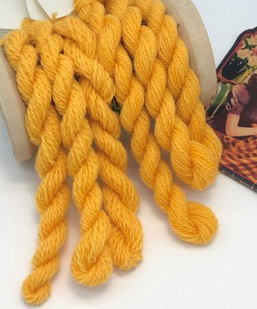 Hand dyed skeins of wool thread in size 8 and size 15 in a yellow that's almost but not quite gold.  Softly variegated.