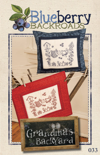 Hand embroidery pillow or wall hanging with a clothesline strung between two birdhouses done in redwork and bluework.