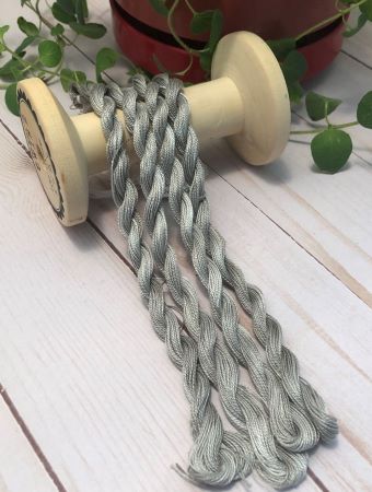 Four skeins of hand dyed Pearl Cotton threads in a slightly variegated medium to dark gray.