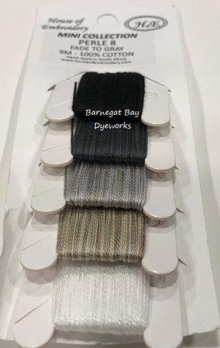 A card with five colors of House Of Embroidery  variegated #8 Perle Cotton threads hand dyed - black, charcoal, medium gray, brownish gray and white.