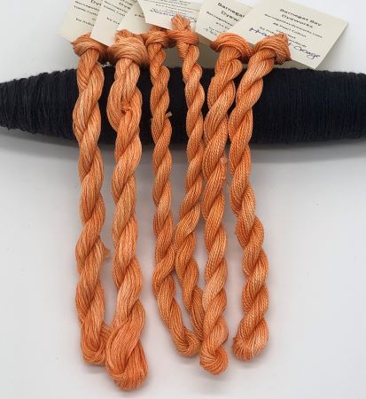 Hand dyed threads in 6 strand embroidery floss and sizes 12 and 8 pearl cotton in a lightly variegated medium orange.