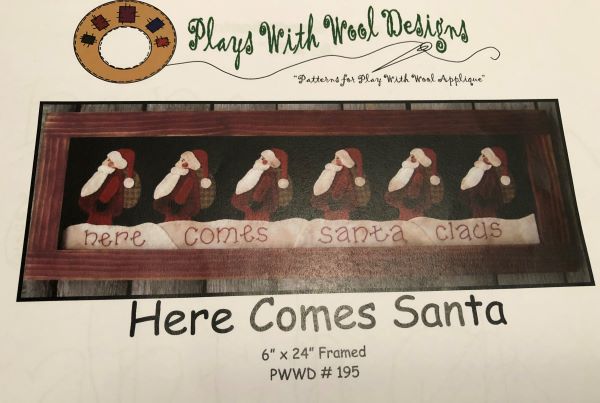 Pattern cover with 6 Santas lined up in the snow done in wool applique.  Here Comes Santa Claus is stitched below them.