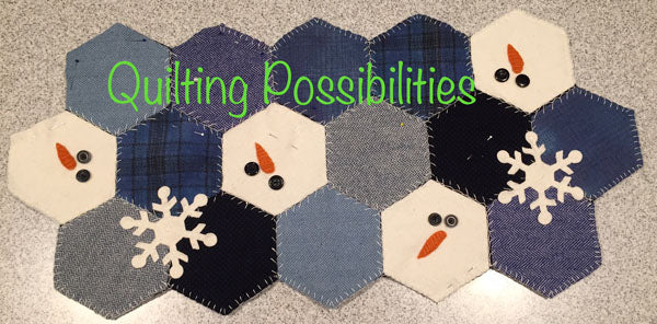 Wool applique hexagon runner in blue wools with four white hexies turned into Snowmen with eyes and noses, also two wool applique snowflakes.