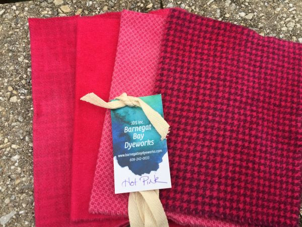 Four pieces of hand dyed wool in a bright deep pink, three textures and a solid