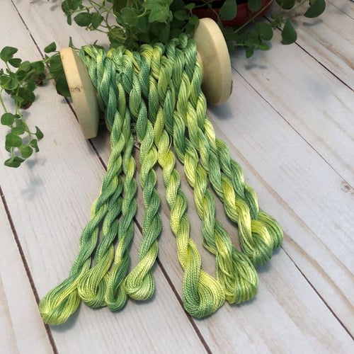 Hand dyed threads in a variegated green and yellow.  6 strand embroidery floss and #12 and #8 pearl cottons available.