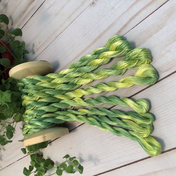 Hand dyed threads in a variegated green and yellow.  6 strand embroidery floss and #12 and #8 pearl cottons available.