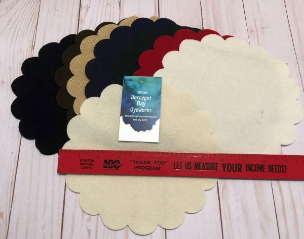 Die cut, scalloped round wool mats for wool applique in solid colors of black, brown, tan, dark green, red, white and cream.