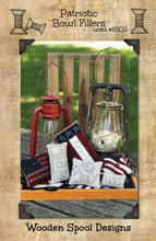 Load image into Gallery viewer, Pattern cover for Patriotic Bowl Fillers three wool applique bowl fillers - a flag, rectangle striped with &quot;America&quot; stitched and a flag in the shape of a star - and three hand embroidered bowl stuffers with a flag and &quot;Old Glory&quot;, a square with &quot;4th of July&quot; and a small rectangle with &quot;USA&quot;.
