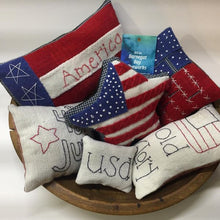 Load image into Gallery viewer, Patriotic Bowl Fillers shown made out of our kit - three wool applique bowl fillers - a flag, rectangle striped with &quot;America&quot; stitched and a flag in the shape of a star - and three hand embroidered bowl stuffers with a flag and &quot;Old Glory&quot;, a square with &quot;4th of July&quot; and a small rectangle with &quot;USA&quot;.
