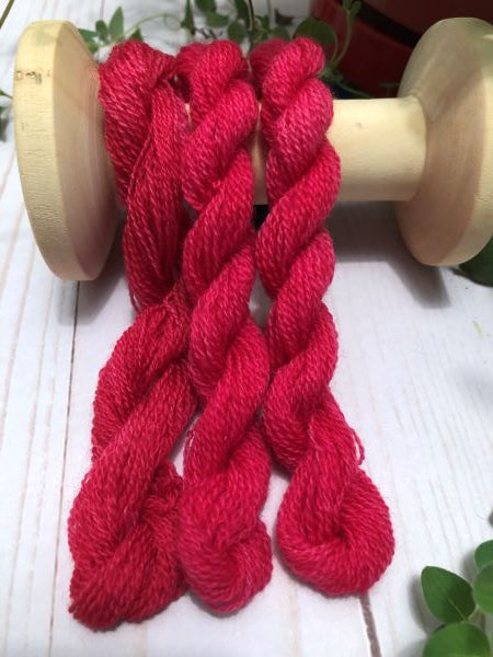Hand dyed, dark pink wool thread, slightly variegated.