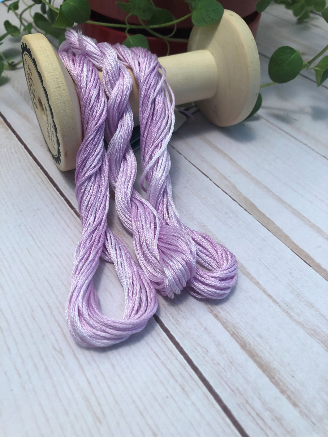 Three skeins of a variegated 6 strand floss in light to medium plum purple color .