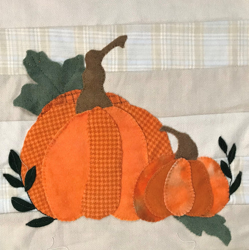 Close up of the two wool applique pumpkins on one end of our table runner sample.