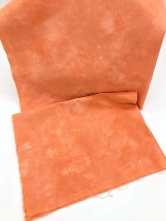 Mottled hand dyed 100% cotton fabric in a warm orange like pumpkin pie