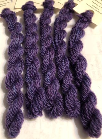 his hand dyed, wool thread is a medium dark, variegated purple with slight touches of blue