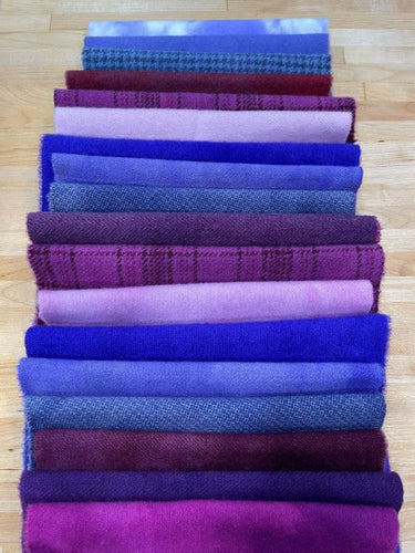 A vertical stack of blue purples and red purples hand dyed wools