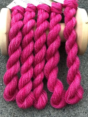 Hand dyed, medium dark, variegated pink wool skeins of thread.