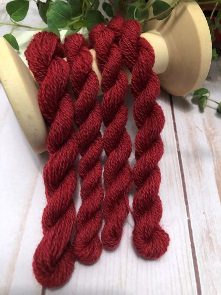 Skeins of a warm, medium dark, hand dyed wool thread with hints of brown.