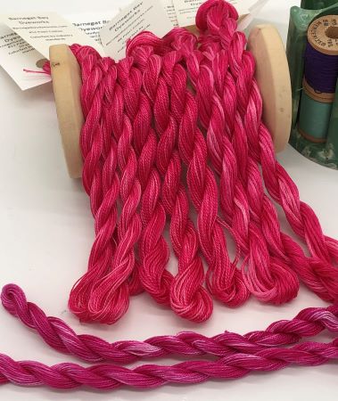 Hand Dyed Threads in a red pinky color with Cherry Fizz threads show for color comparison.   Threads in 6 strand floss and pearl cottons 8 & 12.