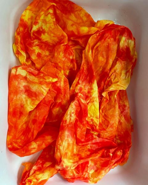 Red and yellow hand dyed and painted, mottled 100% cotton scrunched up in a sink.