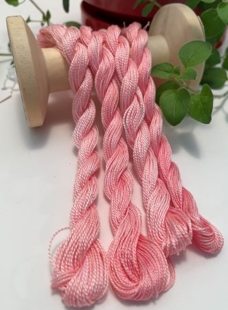 Hand dyed skeins of a softly variegated #8 pearl cotton in a salmon color.
