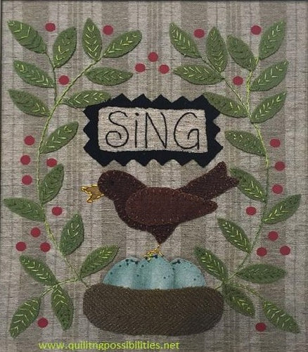 Sing wool applique on cotton wall hanging showing our wools in our kit with a robins nest with eggs, a robbin and greenery on both sides with the word 