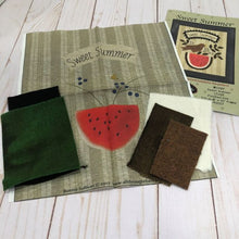 Load image into Gallery viewer, Barnegat Bay Dyework&#39;s wool applique kit for Sweet Summer showing  green and brown hand dyed wools, white and black yarn dyed wools, the preprinted background and the pattern cover for a project with a robin, leaves and berries on top of a sliced watermelon, with a banner that says &quot;Sweet Summer&quot;.
