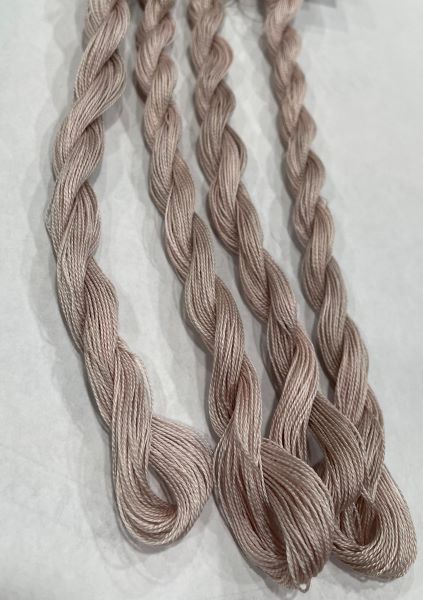 Skeins of hand dyed #8 Pearl Cotton in subtly variegated tans.