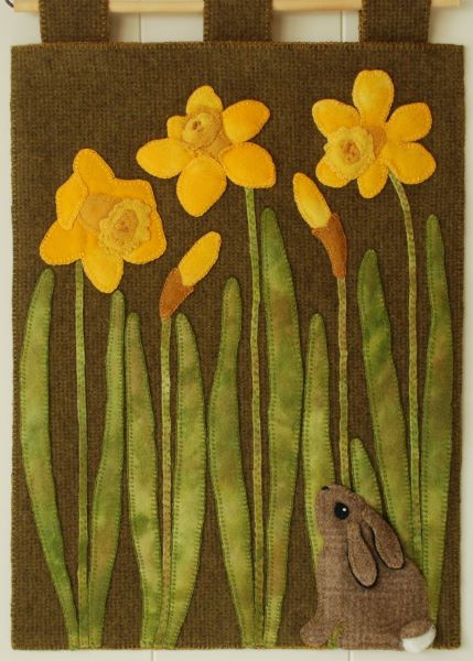 Pattern cover for wool applique scene of a tiny brown bunny looking up at daffodils